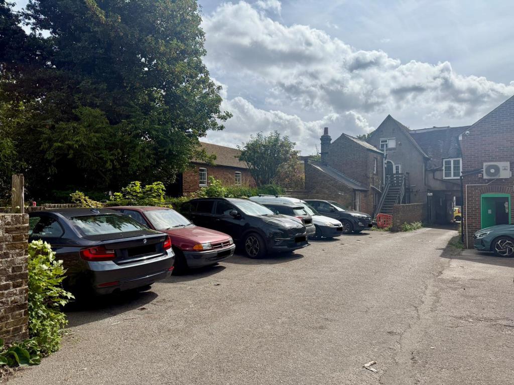 Lot: 64 - HIGH STREET COMMERCIAL PREMISES WITH UPPER PARTS AND PARKING - Rear showing parking area